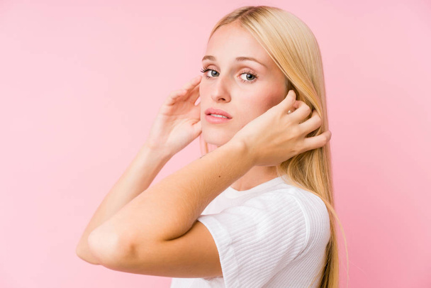 Mladá blondýna žena tvář detailní izolované na růžovém pozadí - Fotografie, Obrázek
