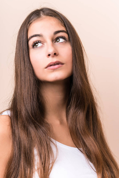 Young cute caucasian woman against a beige background - Fotó, kép
