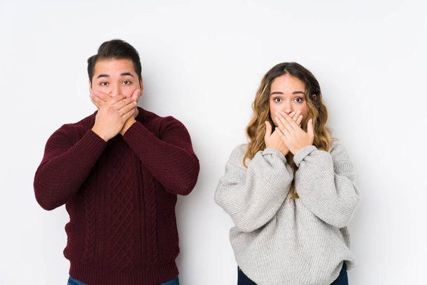 Young couple posing in a white background shocked covering mouth with hands. - Photo, Image