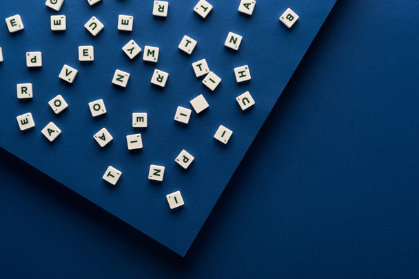 Mavi arkaplana dağılmış küplerin üstündeki harflerin üst görünümü - Fotoğraf, Görsel