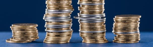 stacks of metal silver and golden coins on blue background, panoramic shot - Foto, afbeelding