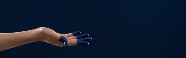 bijgesneden weergave van vrouwelijke hand met geschilderde vingers geïsoleerd op blauwe achtergrond, panoramisch schot - Foto, afbeelding