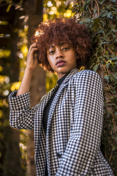 stylish young attractive african american woman posing in park - 写真・画像