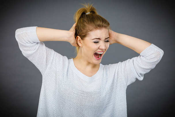 Unhappy woman screaming and yelling in pain - 写真・画像