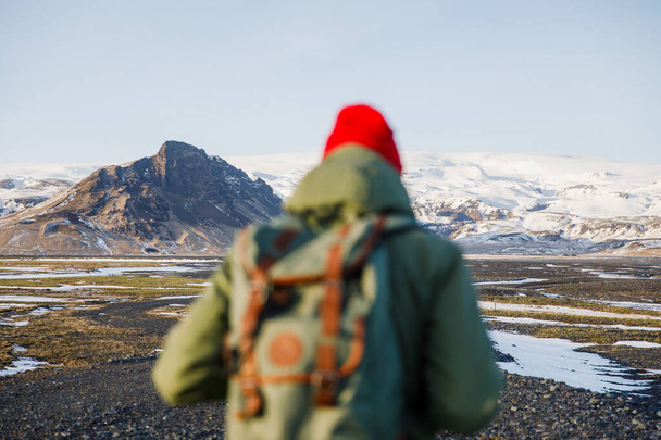 tourist man enjoy waking on black road on Iceland on mountains background - Photo, Image
