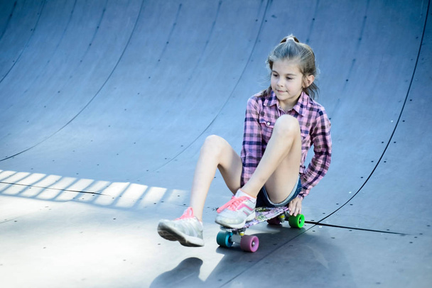 klein meisje skateboard zittend op een skateboard - Foto, afbeelding