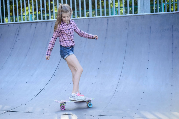 Teenager-Mädchen übt Skateboarding, draußen im Skateboard-Park - Foto, Bild
