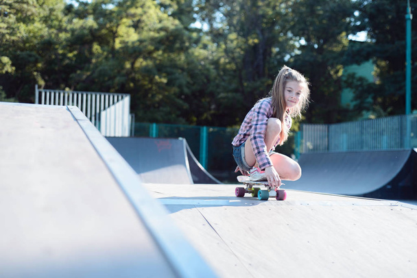 portret van een actieve tiener meisje, het uitvoeren van een skateboard truc - Foto, afbeelding