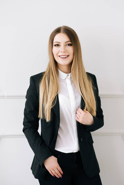 Portrait of a beautiful young stylish businesswoman in a suit on a white background. - Fotografie, Obrázek