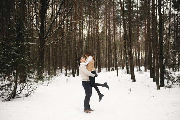 Winter love story on ice. Stylish guy and girl with walk in snowy forest. Romance - Fotografie, Obrázek