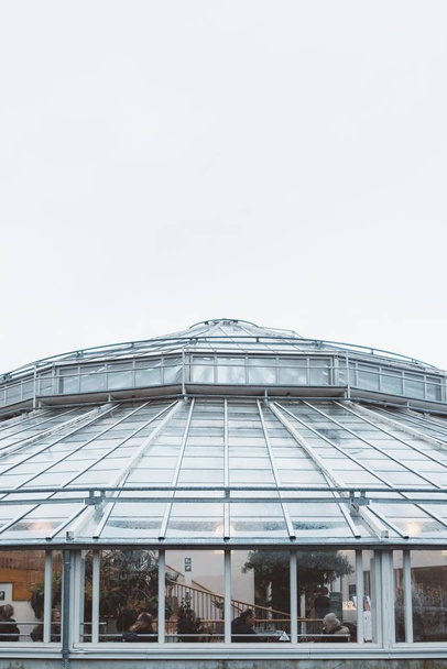 A closeup shot of a clear glass building during daytime under a cloudy sky - Photo, image