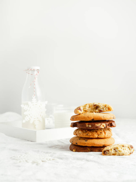 Selectie van zelfgemaakte koekjes, melk, winterdecor op witte achtergrond - Foto, afbeelding