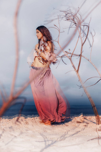 Beautiful young boho style woman outdoors with dry branches - Photo, image
