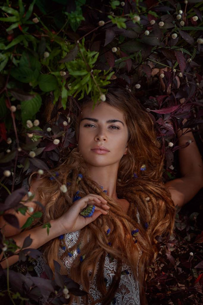 piękna dziewczyna leżąc na trawie z kwiatami - Zdjęcie, obraz