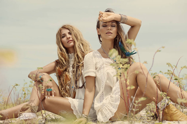 Two beautiful bohemian style women posing outdoors - Фото, зображення