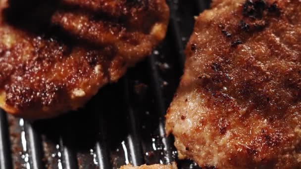 Hamburger paszteciki grillujące na otwartym grillu. Zamknij pyszne paszteciki mięsne skwierczące. gotowanie domowe jedzenie - Materiał filmowy, wideo