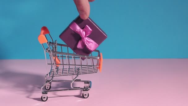 Καλάθι αγορών. Καλάθι αγορών με πολύχρωμα κουτιά δώρων, παρουσιάζει την έννοια των αγορών, θέση για το χώρο αντιγραφής κειμένου. e-Commerce, ένα χέρι παίρνει ένα δώρο, online ψώνια - Πλάνα, βίντεο