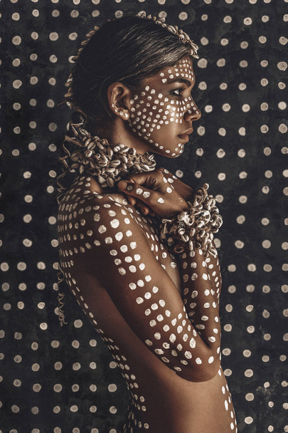 closeup portrait of beautiful young female model painted with dots on skin - Foto, afbeelding