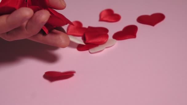 hand puts heart on pink background - Footage, Video