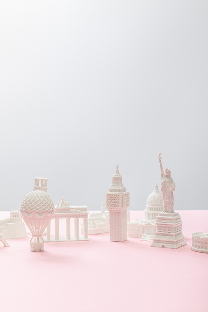 небольшие сувениры из разных стран на серый и розовый
  - Фото, изображение
