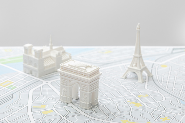 επιλεκτική εστίαση μικρών ειδωλίων στο χάρτη του Παρισιού που απομονώνονται στο γκρίζο   - Φωτογραφία, εικόνα