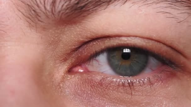 groen oog van een jonge man close-up macro detail. vermoeid, slapeloosheid, de ogen van de duizendjarige, selectieve focus - Video