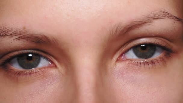 graue, braune Augen, sektorale Heterochromie, die in die Kamera blickt. Porträt einer jungen Frau, Teenager - Filmmaterial, Video