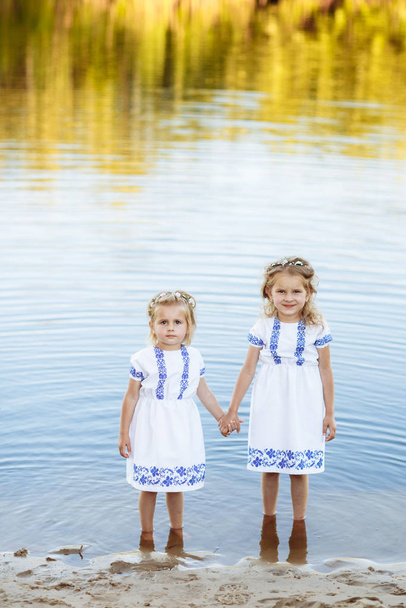 ritratto di due bambine in abiti che si divertono insieme in riva al lago
 - Foto, immagini