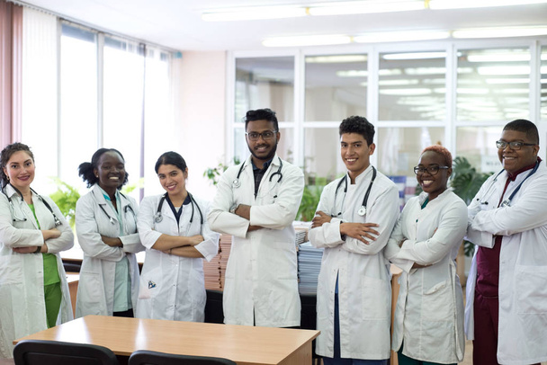 un groupe de médecins dans le couloir de l'hôpital. Equipe de jeunes hommes métis en blouse blanche, avec phonendoscopes, souriants
 - Photo, image