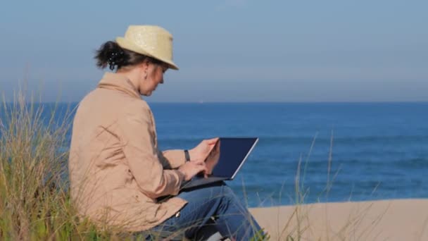 Фрилансер, работающая в ноутбуке на пляже - Кадры, видео