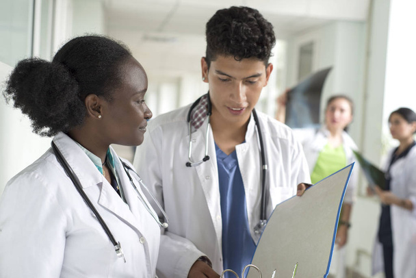 Médico vistiendo blanco capa reunión con paciente femenino
 - Foto, Imagen