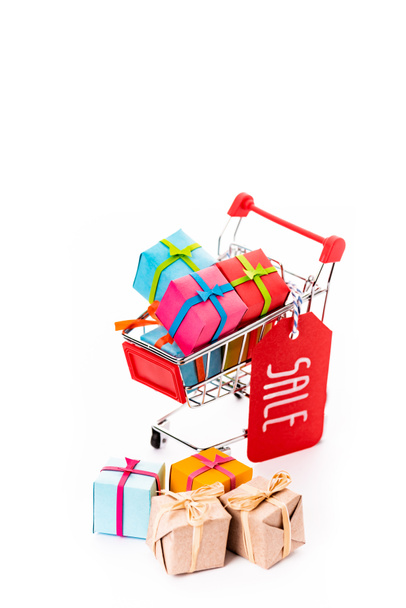 декоративная маленькая корзина с подарочными коробками и ценник с надписью продажи изолированы на белом
 - Фото, изображение