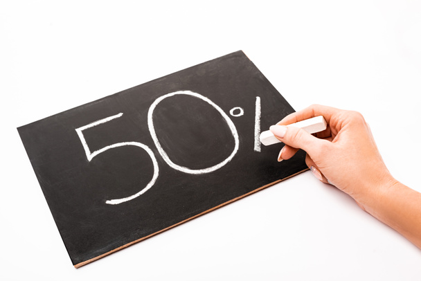 cropped view of woman holding chalk near number 50 and percent sign written on chalkboard isolated on white - Photo, Image