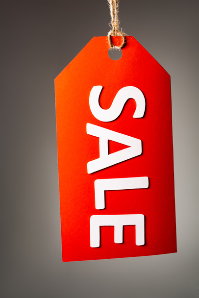 red price tag with sale lettering on black background - Foto, Imagem