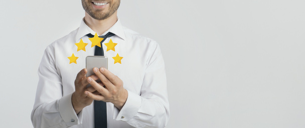 Happy Businessman Ocena aplikacji mobilnej na smartfonie z pięcioma gwiazdami - Zdjęcie, obraz