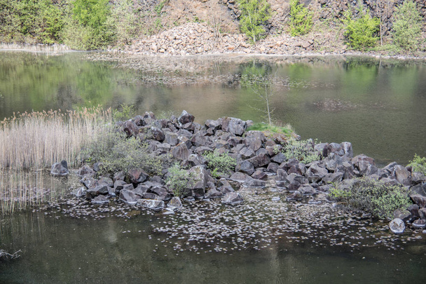 Stok górski z bazaltowej skały nad jeziorem - Zdjęcie, obraz
