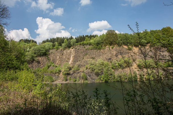 Stok górski z bazaltowej skały nad jeziorem - Zdjęcie, obraz