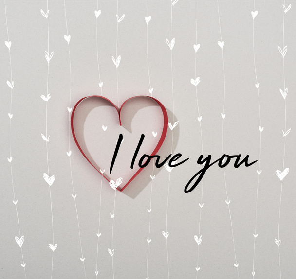 Πάνω άποψη του κόκκινου χαρτιού καρδιά σε γκρι φόντο με I love you lettering - Φωτογραφία, εικόνα