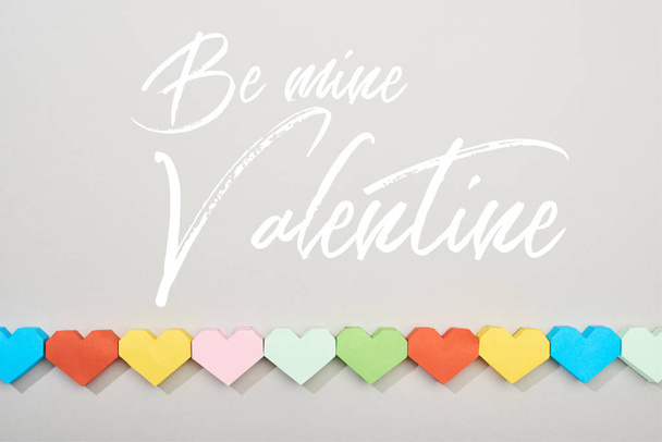Top view of decorative papers in heart shape on grey background with be mine valentine lettering - Fotoğraf, Görsel