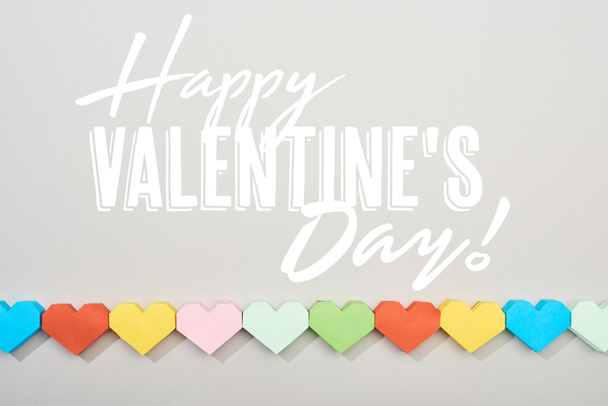 Horní pohled na dekorativní papíry ve tvaru srdce na šedém pozadí s šťastným Valentýna ilustrace  - Fotografie, Obrázek