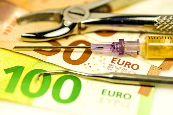 οδοντιατρικές λαβίδες με χαρτονομίσματα του ευρώ - Φωτογραφία, εικόνα