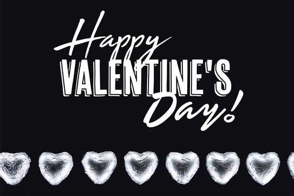 Top view of heart shaped candies isolated on black with happy valentines day lettering - Photo, Image