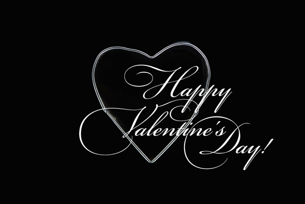 Top view of metal wire in heart shape isolated on black with happy valentines day illustration - Foto, imagen
