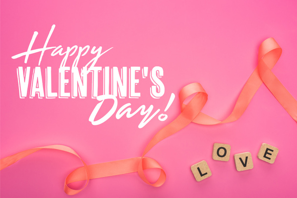vue du haut du ruban courbé et des blocs de bois avec lettrage d'amour isolé sur rose avec illustration heureuse de la Saint-Valentin
 - Photo, image