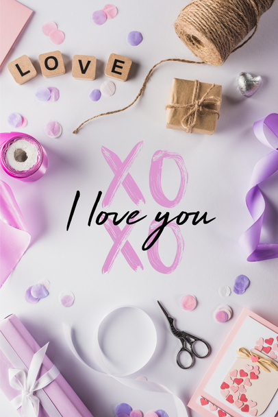 top view of valentines decoration, gifts, handiwork supplies and love lettering on cubes on white background with xoxo i love you illustration - Фото, изображение