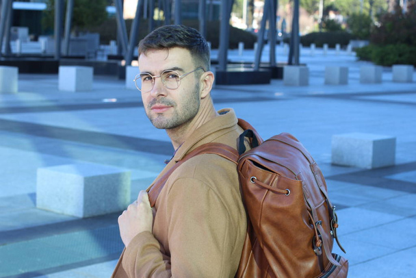 close-up portrait of handsome young man in stylish clothes with leather backpack - Photo, Image