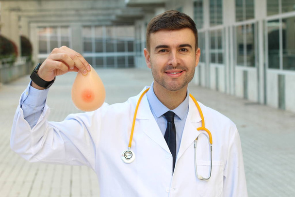 Ethnic plastic surgeon holding silicon implants - Photo, Image