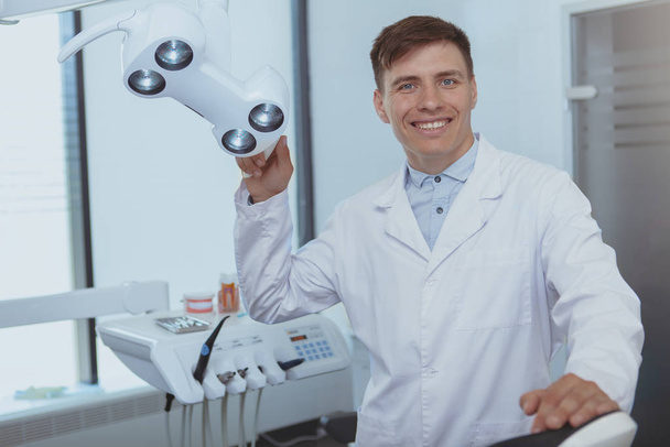 Hezký mužský zubař pracující na klinice - Fotografie, Obrázek