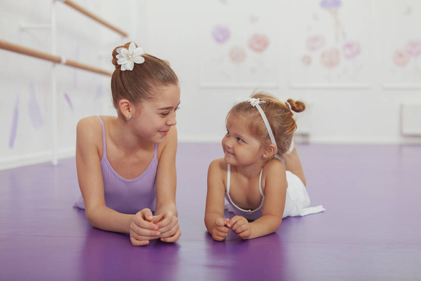 Charming two young ballerinas practicing at ballet class - 写真・画像