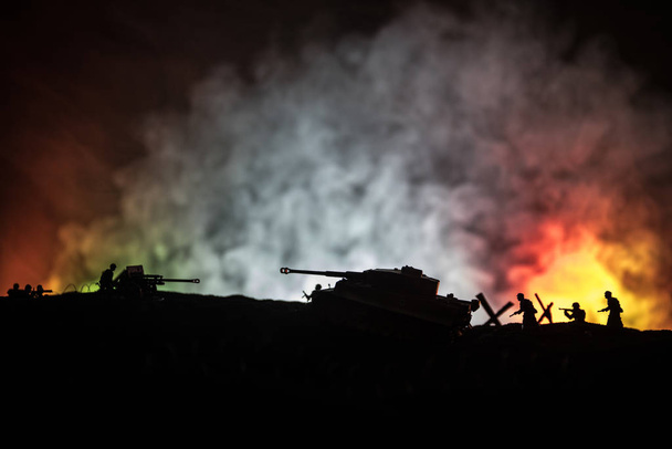 戦争の概念。●戦争霧空を背景に戦闘シーンを戦うミリタリーシルエット、夜の曇りスカイラインの下に第一次世界大戦ドイツ戦車のシルエット。攻撃シーン。装甲車と歩兵. - 写真・画像